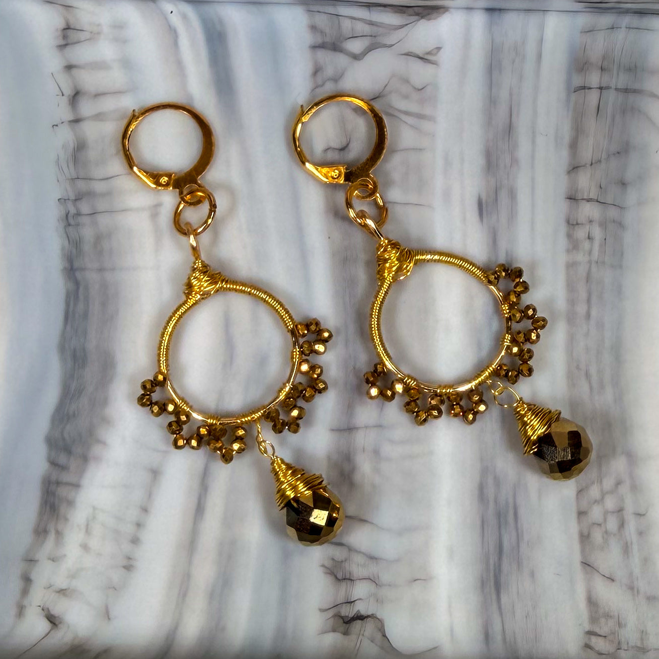 Gold sunburst hoop earrings with crystal tear drop wire wrapped charm with huggie closure and gold crystal beads